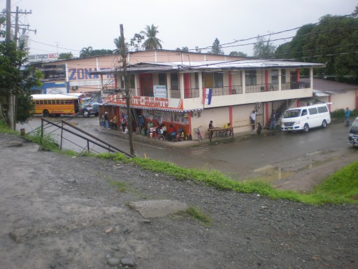 The stand to buy a bus ticket is behind the white van.